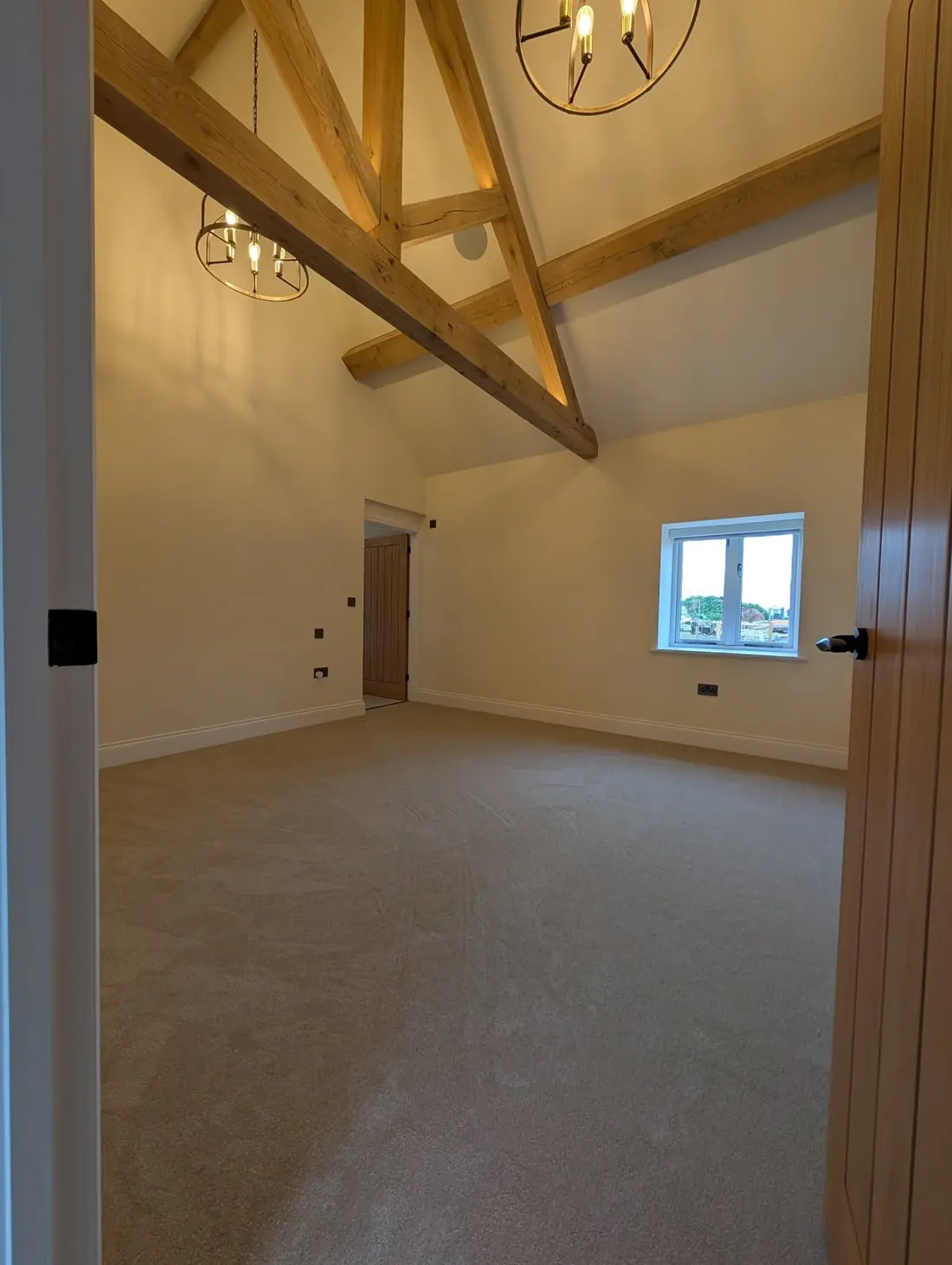 Beige twist carpet fitted in a room with a vaulted ceiling and exposed oak trusses.